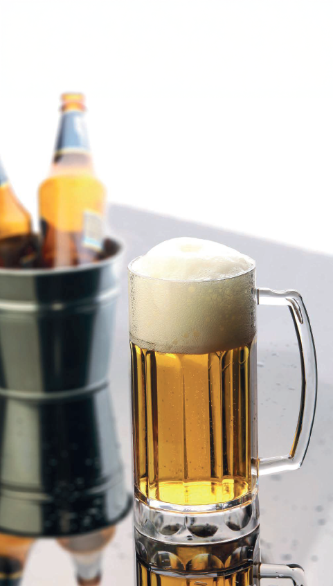 A glass of beer on a table beside a bucket of beer